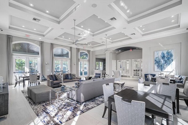 living room with ornamental molding, a towering ceiling, and french doors