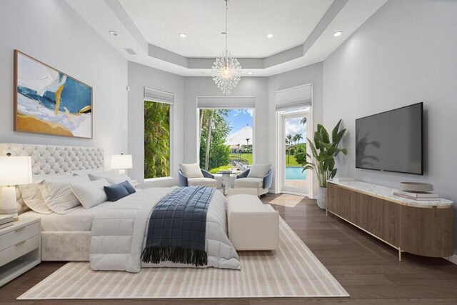 bedroom with access to exterior, dark hardwood / wood-style flooring, a tray ceiling, and a notable chandelier