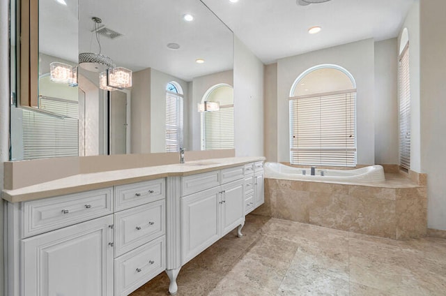 bathroom with tiled tub and vanity