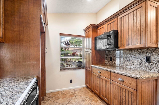 kitchen featuring light stone countertops, a textured ceiling, light tile patterned floors, and tasteful backsplash