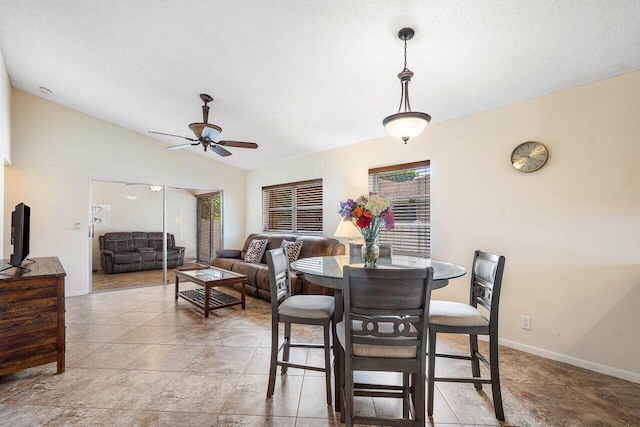 dining area featuring a textured ceiling, vaulted ceiling, and ceiling fan