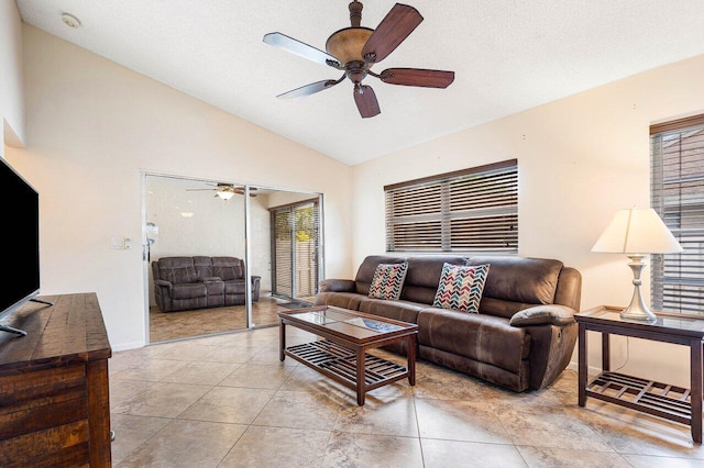 tiled living room with a textured ceiling, ceiling fan, and lofted ceiling