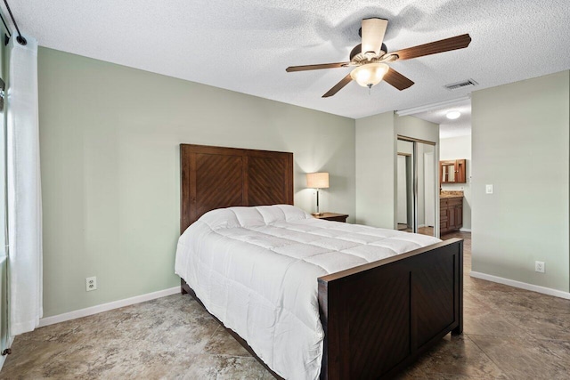 bedroom featuring connected bathroom, ceiling fan, a closet, and a textured ceiling