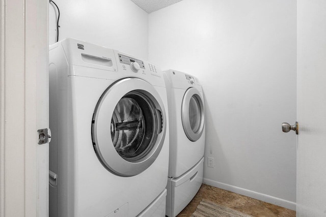 clothes washing area featuring tile patterned flooring and independent washer and dryer