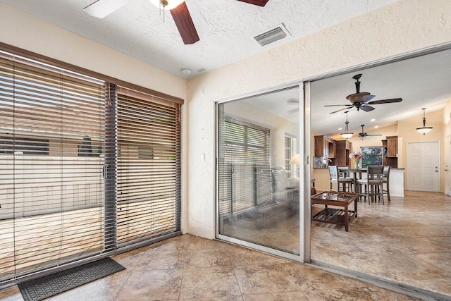 doorway with a textured ceiling and lofted ceiling