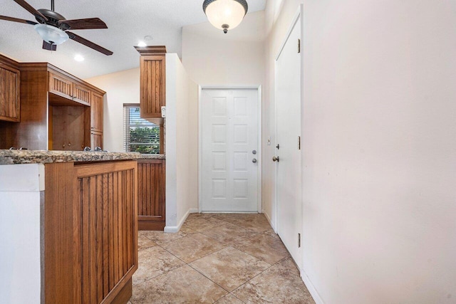 interior space featuring light tile patterned floors, a textured ceiling, ceiling fan, and lofted ceiling