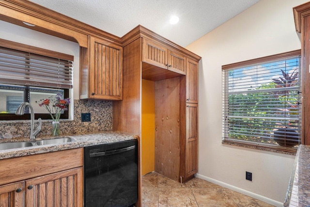 kitchen featuring decorative backsplash, light stone counters, sink, black dishwasher, and lofted ceiling