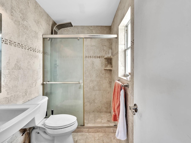 bathroom featuring toilet, walk in shower, and tile walls