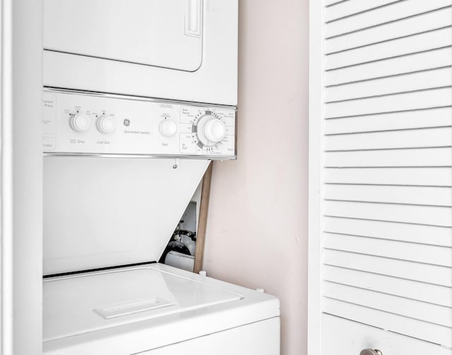 washroom with stacked washing maching and dryer