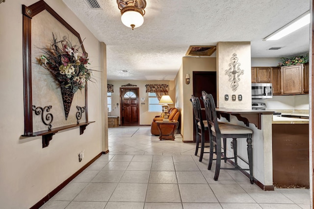 kitchen featuring a textured ceiling and light tile patterned floors