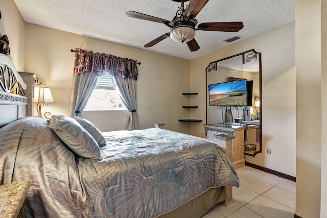 tiled bedroom with a textured ceiling and ceiling fan