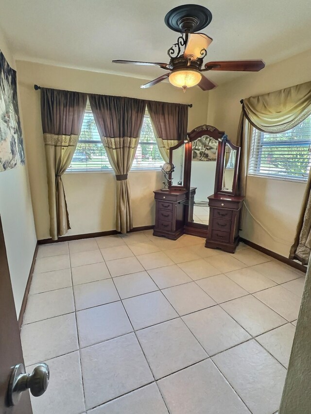 unfurnished bedroom with light tile patterned floors and ceiling fan