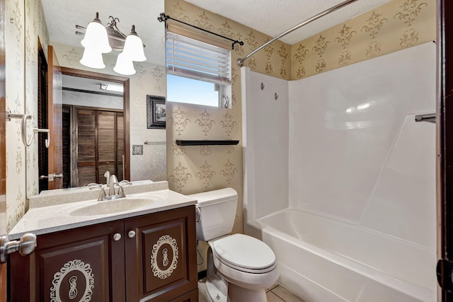 full bathroom featuring vanity, tile patterned floors,  shower combination, toilet, and a textured ceiling