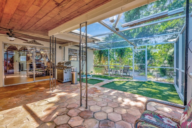 unfurnished sunroom with wood ceiling and ceiling fan