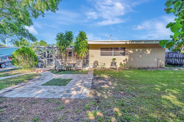 rear view of house featuring a patio and a yard