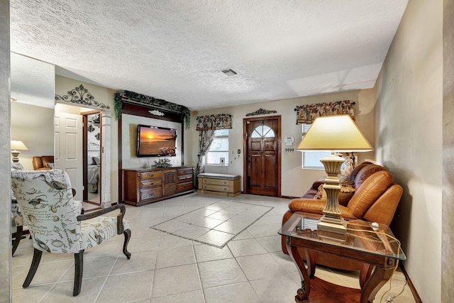 living area with a textured ceiling and light tile patterned floors