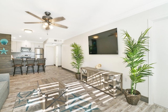 living room with ceiling fan and light hardwood / wood-style flooring