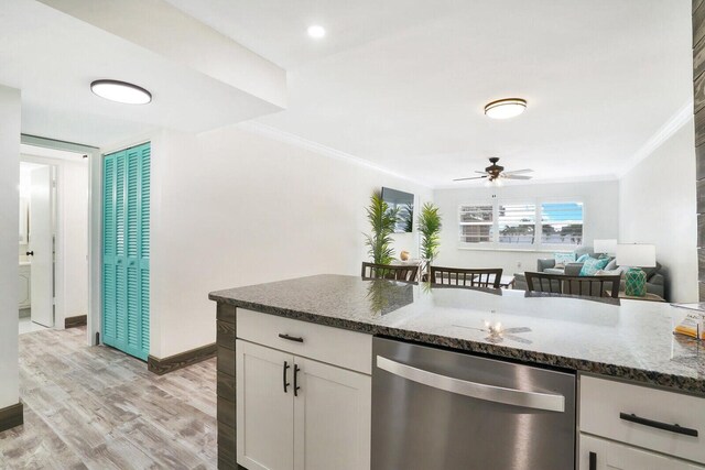 kitchen with white cabinetry, dishwasher, ceiling fan, dark stone counters, and light wood-type flooring