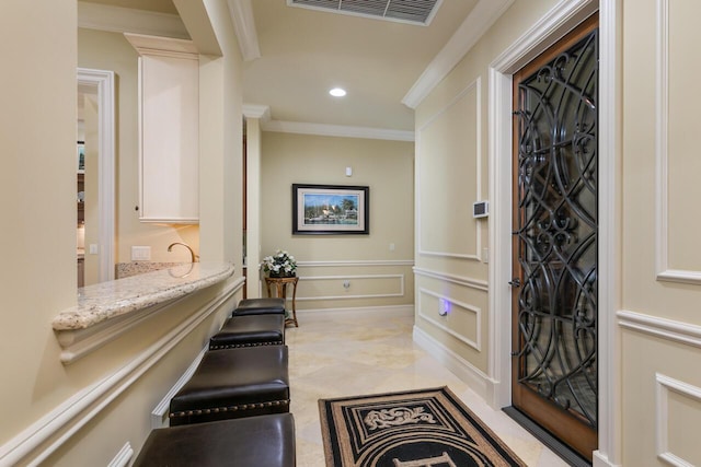 foyer entrance with ornamental molding, recessed lighting, and visible vents