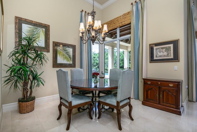 dining room with ornamental molding, a notable chandelier, and baseboards