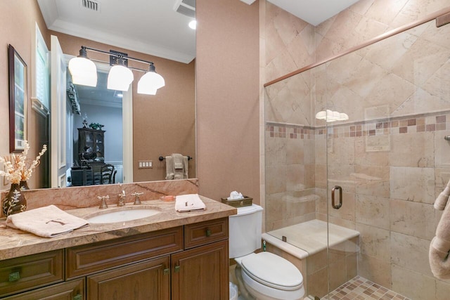 bathroom with toilet, a shower stall, vanity, and crown molding