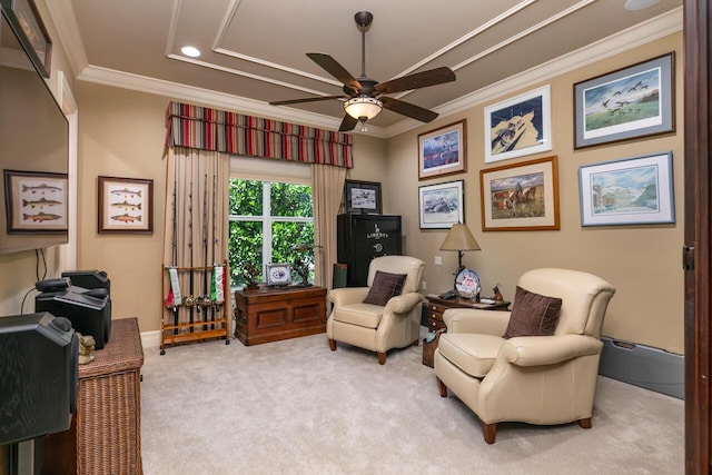 sitting room featuring ceiling fan, ornamental molding, baseboards, and light colored carpet