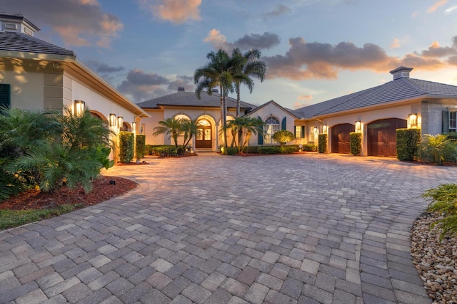 view of front of property with a garage, decorative driveway, and stucco siding