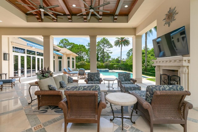 view of patio / terrace with an outdoor living space with a fireplace, a pool with connected hot tub, and a ceiling fan