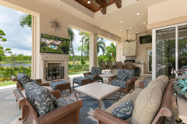 view of patio / terrace featuring an outdoor living space with a fireplace, fence, and ceiling fan