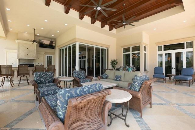 view of patio with french doors, an outdoor kitchen, a ceiling fan, an outdoor bar, and an outdoor living space