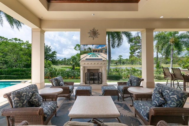 view of patio / terrace with an outdoor living space with a fireplace, fence, and a fenced in pool