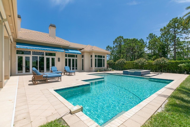 view of swimming pool featuring a pool with connected hot tub, french doors, and a patio