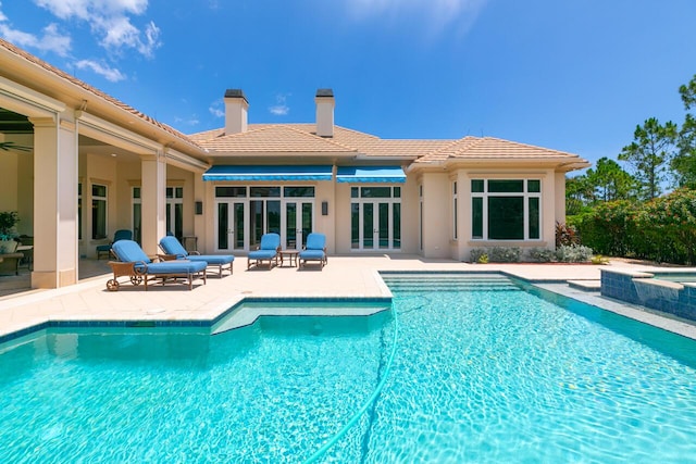 pool with an in ground hot tub and a patio