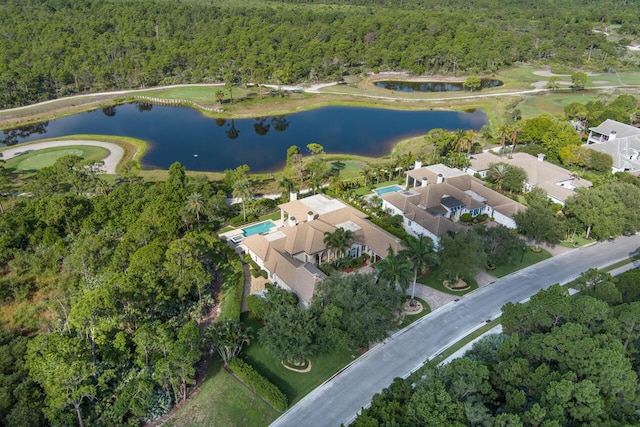 drone / aerial view with a forest view and a water view