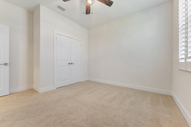 unfurnished bedroom featuring carpet floors, a closet, and ceiling fan