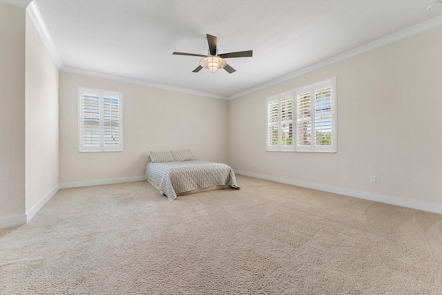 carpeted bedroom with multiple windows, ceiling fan, and crown molding