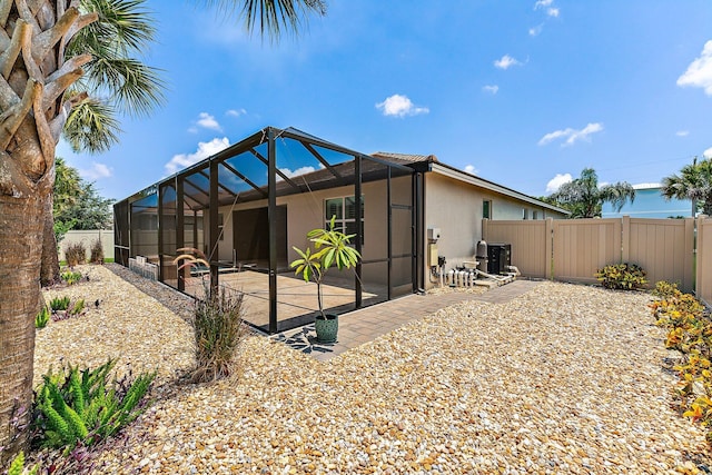 rear view of property with a lanai and a patio