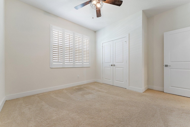 unfurnished bedroom featuring light carpet, a closet, and ceiling fan