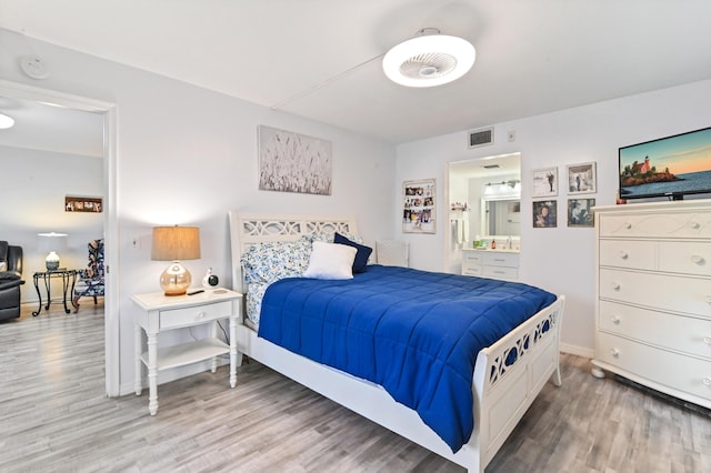 bedroom featuring wood-type flooring and connected bathroom