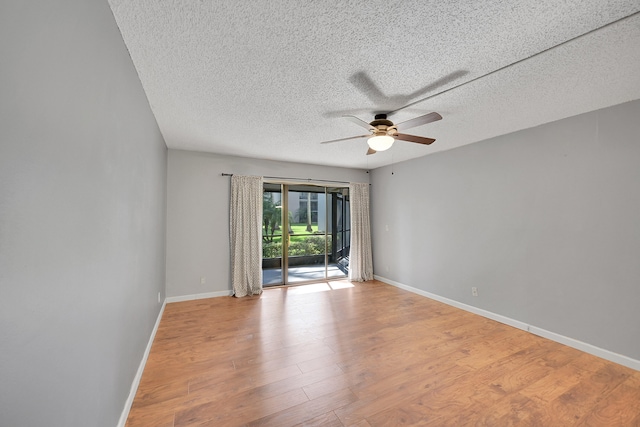 empty room featuring ceiling fan, light wood-type flooring, and a textured ceiling