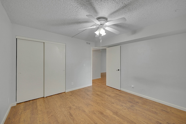 unfurnished bedroom featuring a textured ceiling, light hardwood / wood-style floors, and ceiling fan