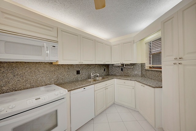 kitchen featuring white appliances, sink, decorative backsplash, light tile patterned floors, and white cabinetry