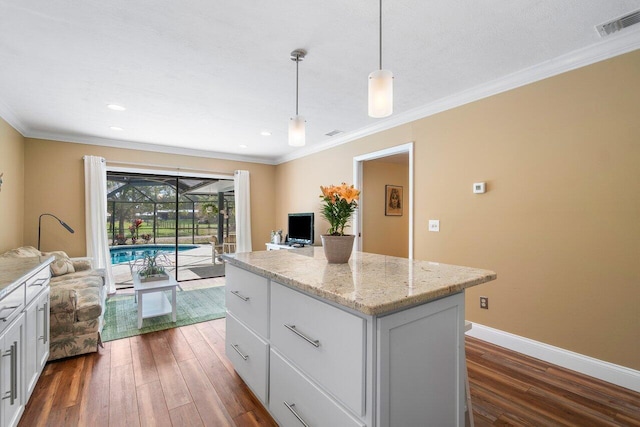 kitchen featuring crown molding, white cabinets, dark wood-type flooring, a center island, and pendant lighting