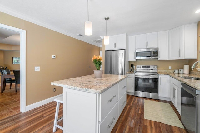 kitchen with white cabinetry, pendant lighting, a center island, appliances with stainless steel finishes, and dark wood-type flooring