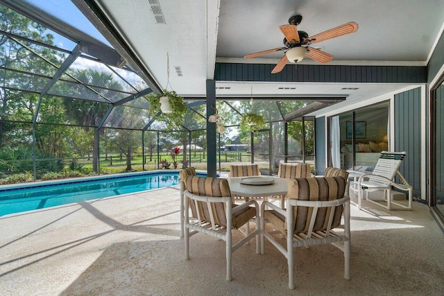 view of swimming pool with a patio, ceiling fan, and a lanai