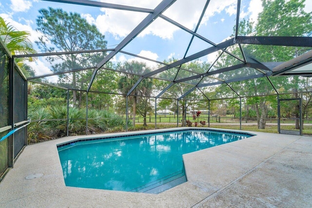 view of pool with a patio and glass enclosure