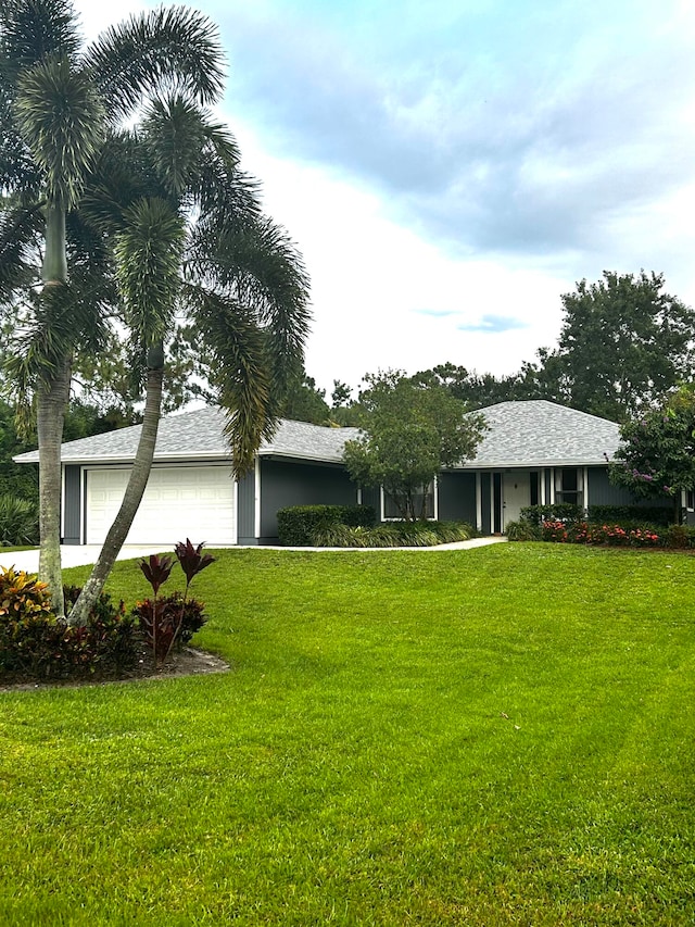 ranch-style home with a garage and a front lawn