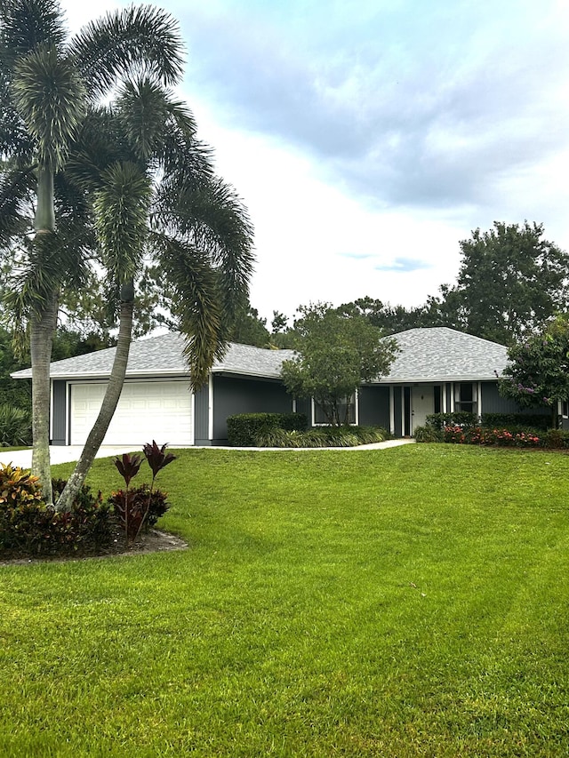 ranch-style house with a garage and a front lawn