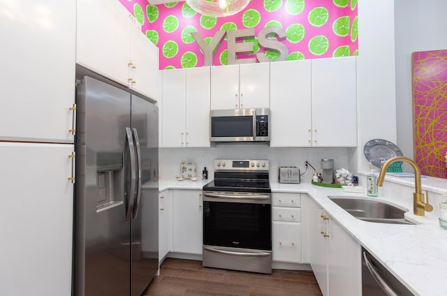 701 S Olive Ave Unit 409, West Palm Beach, FL 33401 - kitchen with dark wood-style flooring, white cabinetry, light stone countertops, appliances with stainless steel finishes, and a sink