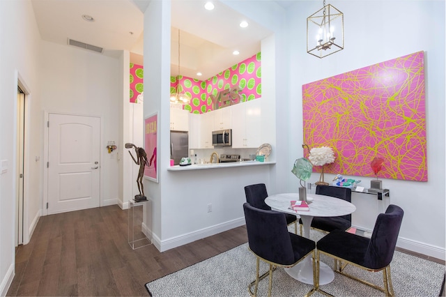 701 S Olive Ave Unit 409, West Palm Beach, FL 33401 - dining space featuring a chandelier, visible vents, a high ceiling, and dark wood finished floors